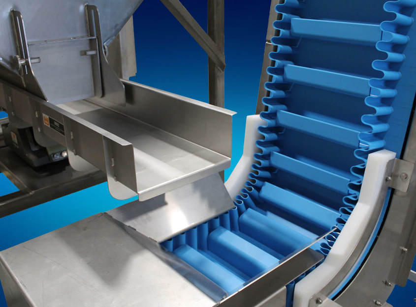 Metering hopper dispenses even product onto stainless steel vibratory feeder for gentle transport to hygienic conveyor.